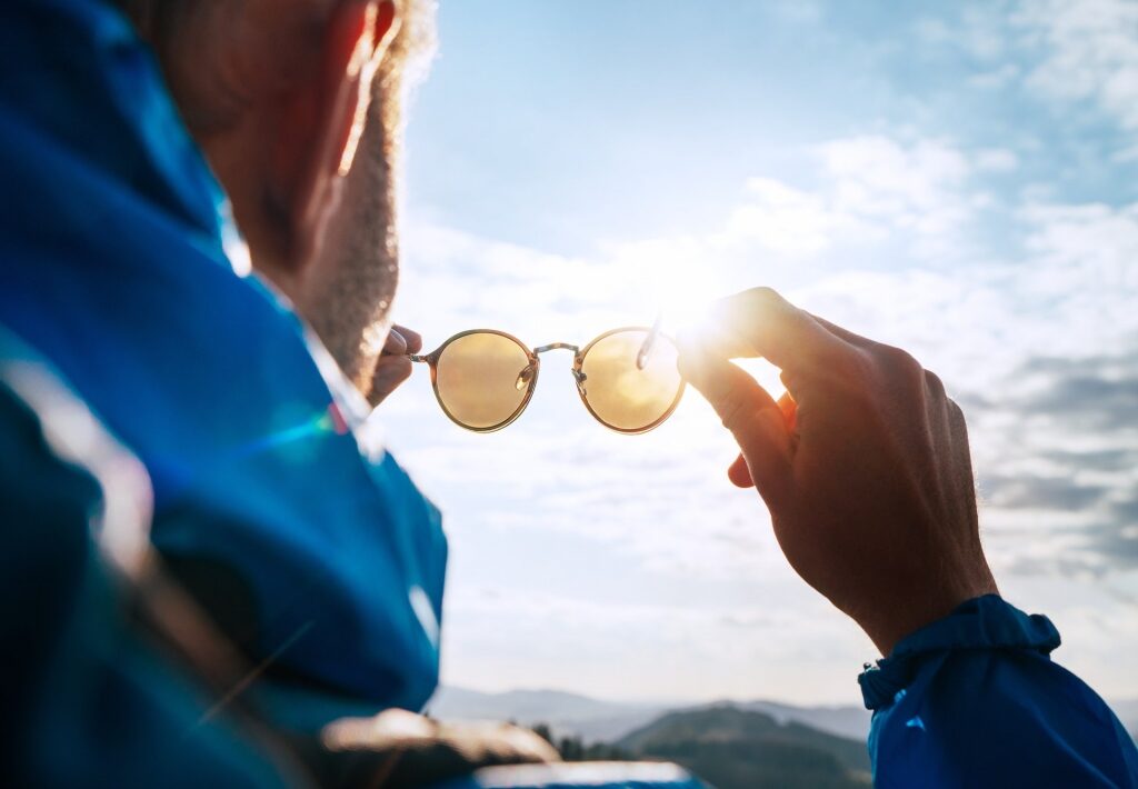 Man holding out polarized sunglasses
