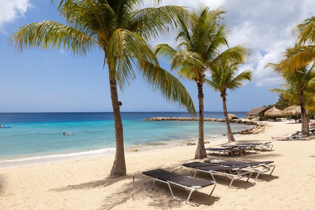 https://www.celebritycruises.com/blog/content/uploads/2023/06/clearest-water-in-the-caribbean-blue-bay-beach-curac%CC%A7ao-view-1024x683.jpg