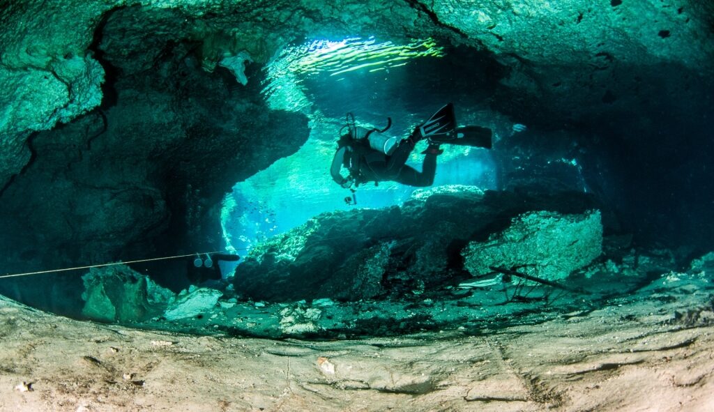 Person diving inside Cenote Nicte-Ha