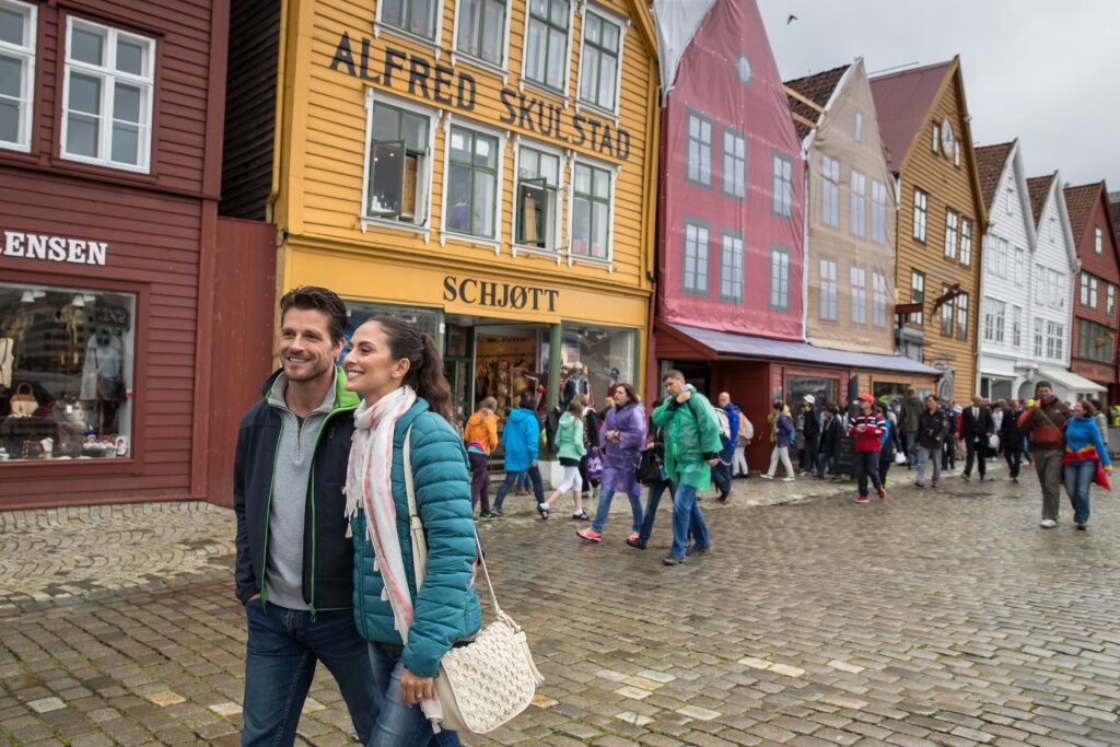 Couple walking around Bryggen in Bergen Norway