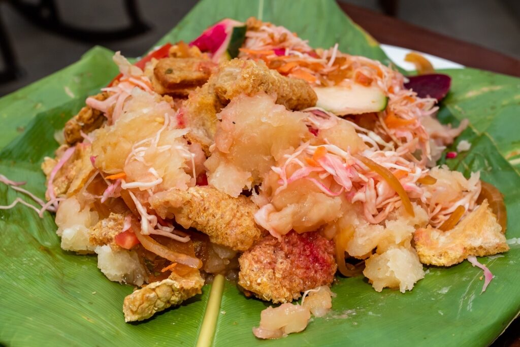 Yuca con chicharrón on a leaf