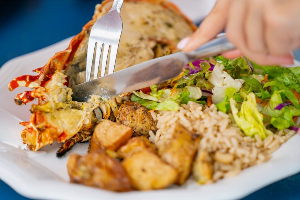 Person eating grilled lobster