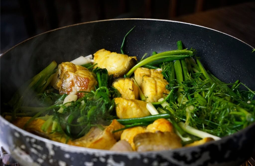 Cooking Chả Cá Lã Vọng in a pan